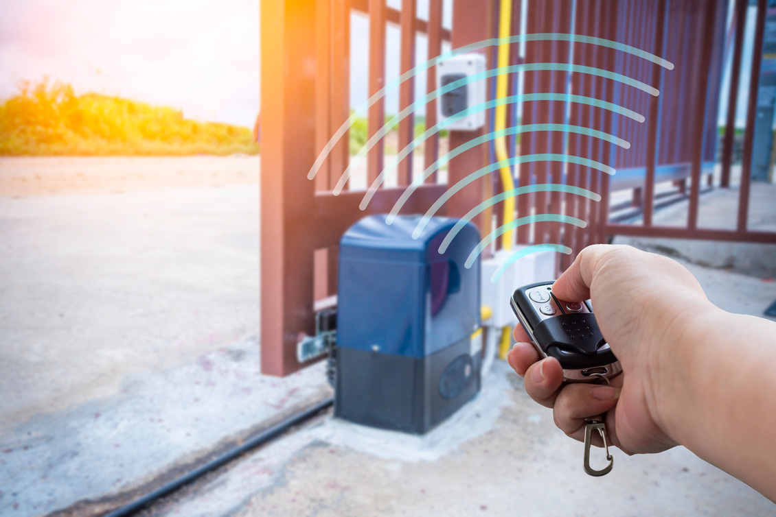 Signal of remote control when person open automatic gate at house with sunlight rays